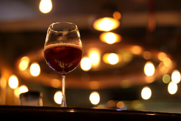 One Goblet filled with Red Wine with thumbprints on it.