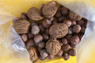 hazelnuts and walnuts lie in a transparent bag; top view, close-up