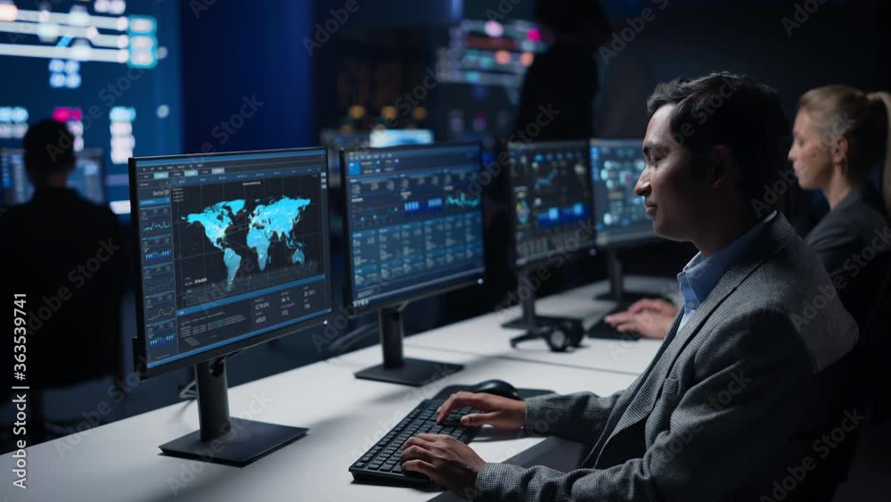 Aufkleber confident male data scientist works on personal computer in big infrastructure control room. stock m