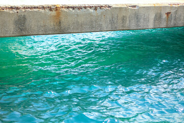Fototapeta na wymiar Concrete beam bridge over water . Turquoise Colored Sea Water 