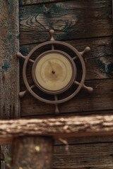 An old barometer in the shape of a steering wheel hangs on the wall of an old house