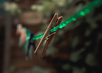 An old wooden clothespin hanging from a wet clothesline