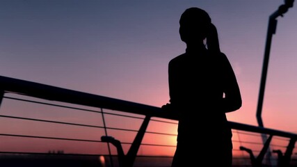 silhouette woman jogging on the bridge at sunrise slow motion jogger running to the camera view on the amazing sky with rising sun