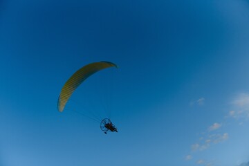 Paraglider with yellow parachute taking off