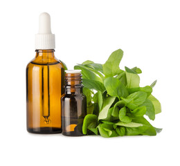 Essential peppermint oil in brown glass bottles and green fresh mint leaf on branch isolated on white background. Aromatherapy and herbal medicine