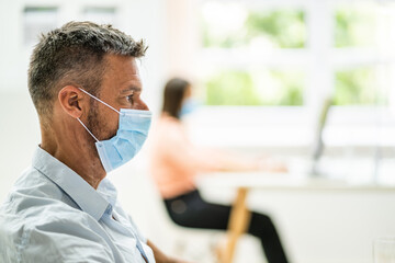 Mature Male Worker In Office Wearing Face Mask