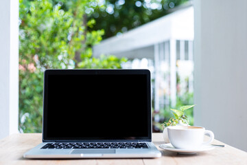 Fototapeta premium Mockup of laptop computer with empty screen with coffee cup on table of the coffee shop background,Black screen