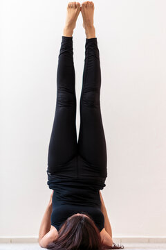 Young woman doing yoga pose. Vertical view of supported legs up the wall Viparita Karani asana