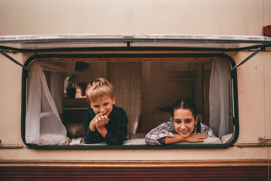 Happy Family On A Camping Trip Relaxing In The Autumn Forest. Camper Trailer. Fall Season Outdoors Trip