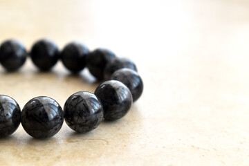 Black rutilated quartz bracelet.  Selective focus.  Copy space is on the right side. 