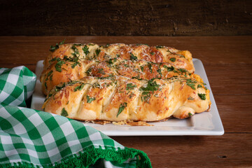 Bread stuffed with chicken and cheese and parsley on top. Wooden rustic background.