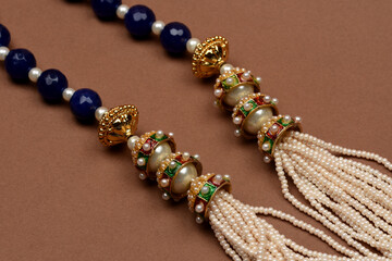 Indian traditional jewelry on brown background with earrings.pearl and blue stone necklace,Luxury female jewelry, Indian traditional jewellery,Bridal Gold wedding jewellery