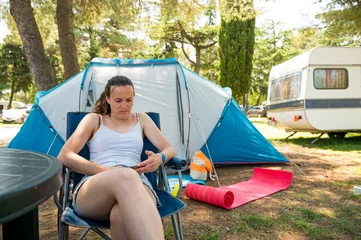 Fotobehang Woman wearing white shirt enjoying holidays infront of camping tent in a resort. © anzebizjan