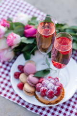 Beautiful and romantic proposal on Saint Valentine's day in Paris - city of love. Bouquet of pink roses, two glasses of wine, macaroons, cake. Eiffel tower on background. Close up copy space. Tonned
