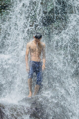 A man standing in the middle of a waterfall
