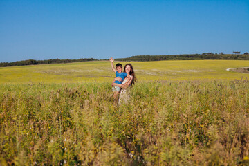 Portrait of a beautiful mom and son on a walk on nature field road