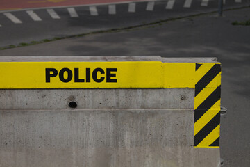 Police sign word on cordon - block  reinforcement made of concrete.