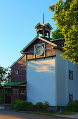 Obraz premium Scenic landscape view of the ancient clock tower during sunset. Decorated by carved wooden platbands. Trinity Monastery of St. Jonas. Blu sky background. Hryshko National Botanical Garden, Kyiv