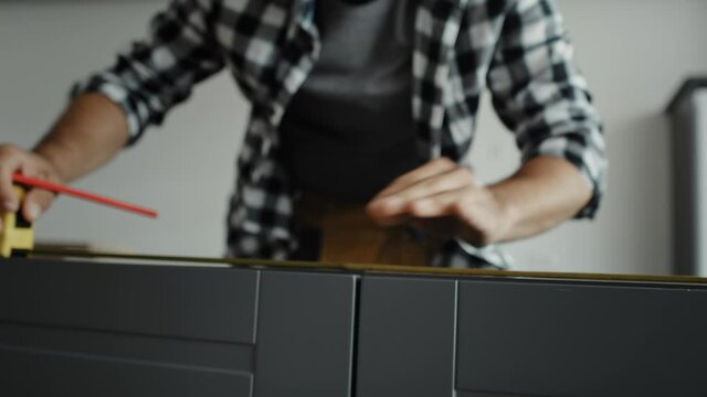 Tracking video of carpenter measuring kitchen furniture. Shot with RED helium camera in 8K