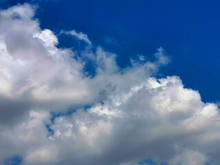 Large white clouds in the blue sky on a clear day