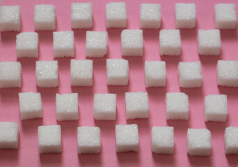 Sugar cubes on pink background
