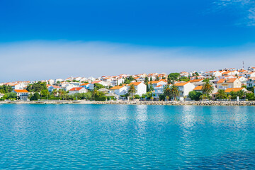 Fototapeta premium Croatia, town of Novalja on the island of Pag, marina with boats and turquoise sea in foreground, tourist destination on Adriatic sea