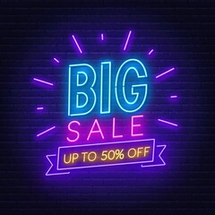 Big Sale neon sign on brick wall background .