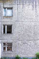 Abandoned panel residential building wall with broken windows