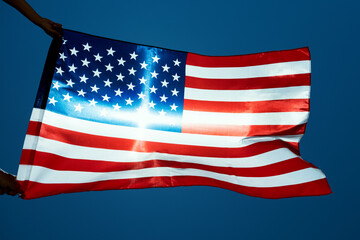 Fototapeta premium man waving an American flag on the wind