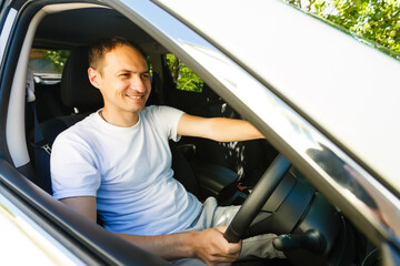 Portrait of an handsome guy driving his car