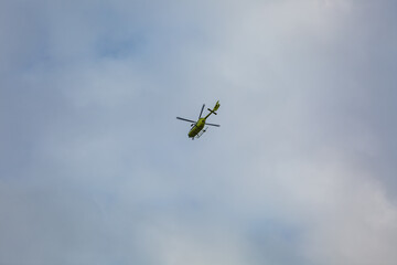 Helicopter flying in cloudy blue sky
