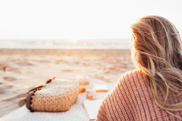 Young blonde woman lying alone on the beach or ocean and look at the horizont. A woman dressed in a...