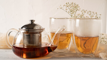 Bleak morning tea in double walled insulated glass mugs and glass teapot. Thermal glass tea cups. Bright morning tea