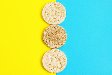 Rice and buckwheat cake on a yellow and blue background. Vertically.