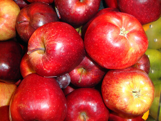 Fototapeta na wymiar Manzanas rojas apiladas en un supermercado 