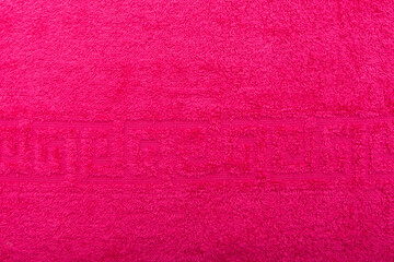 Terry towel, texture, textile background close up. Terry crimson towel background. Color crimson terry towel made of cotton fabric. Structure with uncut thread loops. crimson towel background