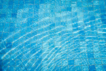 Swimming pool background with sun reflect wave on surface.