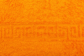 Terry towel, texture, textile background close up. Terry orange towel background. Color orange terry towel made of cotton fabric. Structure with uncut thread loops. orange towel background