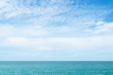 Fototapeta na wymiar White clouds on blue sky over the calm ocean in sunny day at the Gulf of Thailand. Natural background of beautiful seascape.