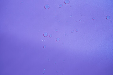 Water drops on a purple background. Texture. Soft calm color.