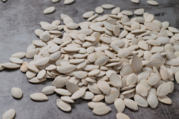 Pumpkin seeds on the cement floor. Healthy eating and diet snack concept.