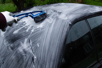 cleaning the tarpaulin roof of the convertible with foam cleaner.