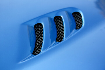 Fototapeta na wymiar Air vents in the hood of a blue sports car