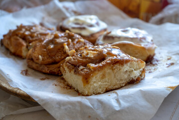 fresh baked homemade cinnamon rolls glazed with classic cream cheese and caramel, traditional cinnabons home baking