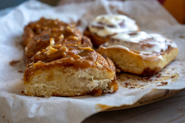 fresh baked homemade cinnamon rolls glazed with classic cream cheese and caramel, traditional cinnabons home baking