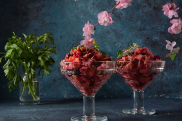 Vinegret or vinaigrette. Traditional Russian red salad with cooked and pickled vegetables, peas, beetroot, in two glass bowls on grey background.
 Vegan healthy dietary food