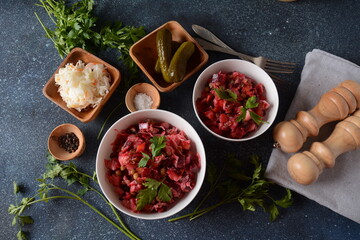 Vinegret or vinaigrette. Traditional Russian red salad with cooked and pickled vegetables, peas, beetroot, in white bowl on grey background.
 Vegan healthy dietary food