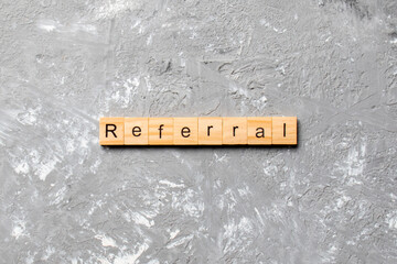Referral word written on wood block. Referral text on cement table for your desing, Top view concept