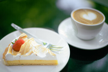A close up photo of lemon tart and a cappuccino.