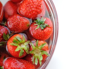 Top view summer fruits. Home strawberry in bowl with water with copy space